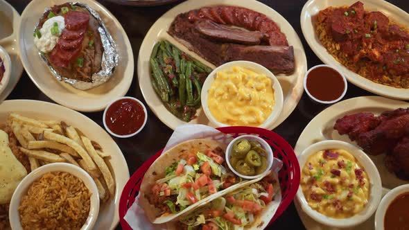 Top down tabletop view of assorted barbecue and Texas comfort food menu items, slider 4K