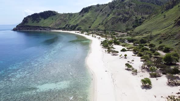 Aerial drone of people, adults, children, kids walking on secluded, remote beach on tropical island