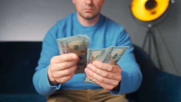 Man Counting US Dollar Bills or Paying in Cash