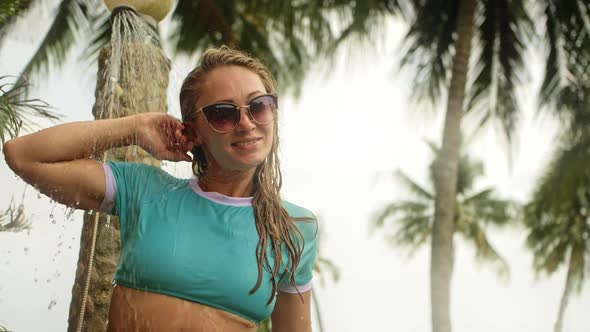 Woman Taking a Shower in Garden Near Hotel