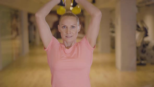 Portrait of Strong Caucasian Sportswoman Training with Dumbbells in Gym. Confident Athletic Woman