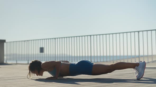 Young Muscular Woman Training Chest in Sunny Morning in City Street