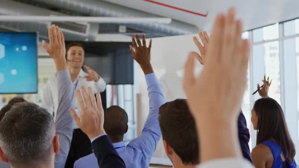 Businessman inviting questions from the audience at a business presentation