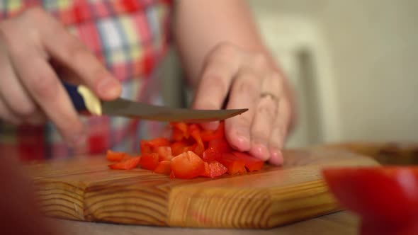 Girl Cuts Tomato for Salad with a Sharp Knife