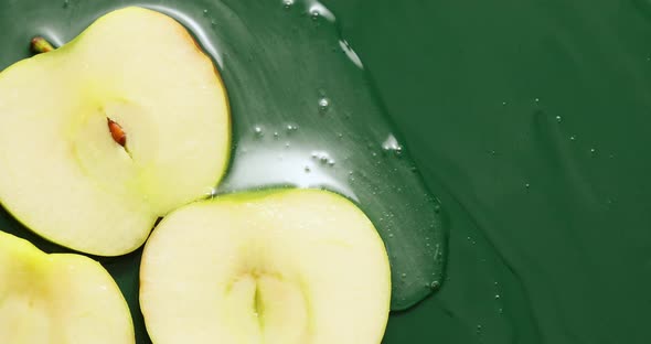 Top view of fresh sliced apples with gel on green background