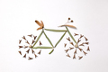 Pattern of leaves and pine seeds in the form of a bicycle on a gray background with copy space - PhotoDune Item for Sale