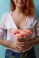 A bouquet of pink roses is holding in hands a sexy red-haired girl around a blue background with - PhotoDune Item for Sale