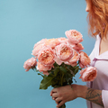 Gentle pink roses in the hands of a girl with a tattoo on a blue background with copy space for text - PhotoDune Item for Sale