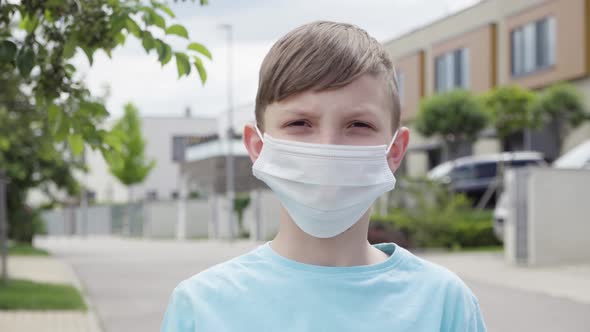 A Young Boy Puts on a Face Mask and Shows a Thumb Down To the Camera, Takes It Off