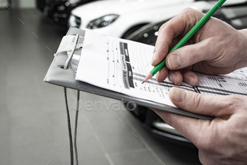 anic writing to the clipboard at workshop warehouse, technician doing the checklist for repair machine a car in the, detailing