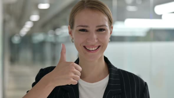 Positive Young Businesswoman Doing Thumbs Up