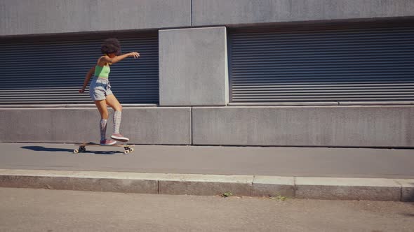 Beautiful young woman cruising around the city with her longboard.