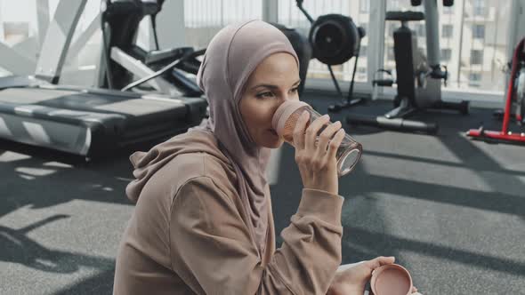 Muslim Woman in Hijab Drinking Water in Gym