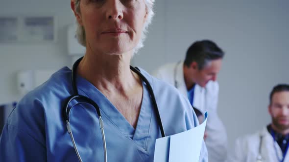 Close-up of Caucasian female doctor standing with medical file in hospital