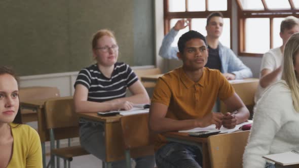 Student raising his hand in high school class