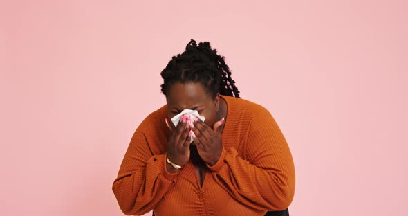 AfroAmerican Plump Model Sneezes and Wipes Nose with Napkin