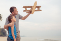 Father and son playing with cardboard toy airplane - PhotoDune Item for Sale