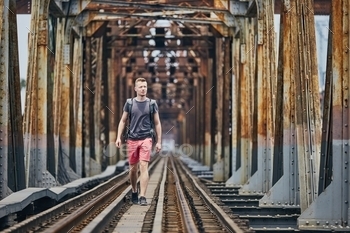 Traveler walking on railway bridge