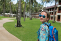beautiful girl with blue backpack on a path with palm trees - PhotoDune Item for Sale