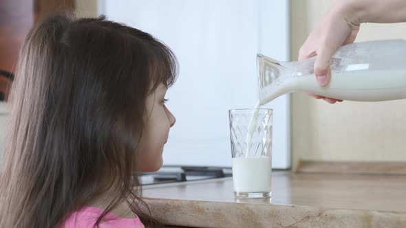 The child is poured milk. 