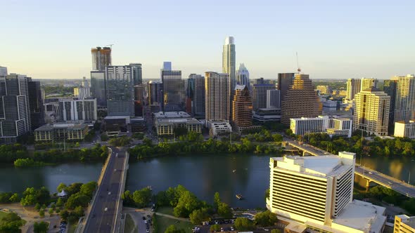Aerial view overlooking the river and the sunlit skyline of Austin, USA - tracking, drone shot