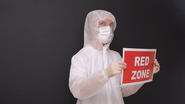 Portrait of Doctor Male in Protective Medical Suit Holding Tablet with RED ZONE Inscription