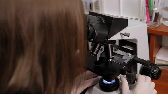 Closeup of a Scientist Looking Into a Microscope in a Laboratory alt
