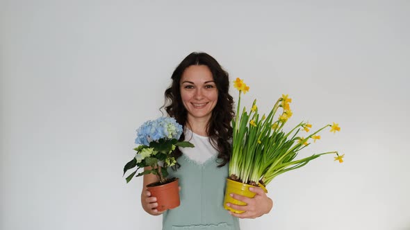 Beautiful Young Woman Florist with Flowers on White Background Smiling at Camera