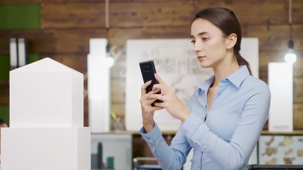 Close Up of Female Architect Taking Photos of Building Model of Sky Scraper