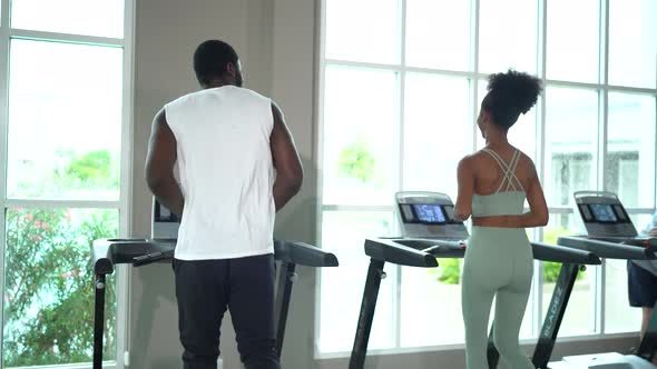 Black skin man and woman running on Treadmill in fitness.