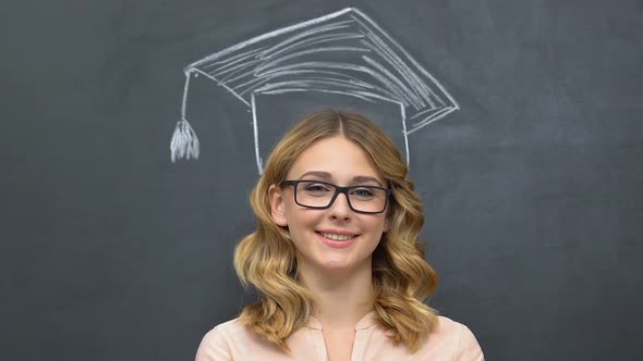 Woman Standing Near Blackboard With Graduation Hat Drawn Over Head, Education