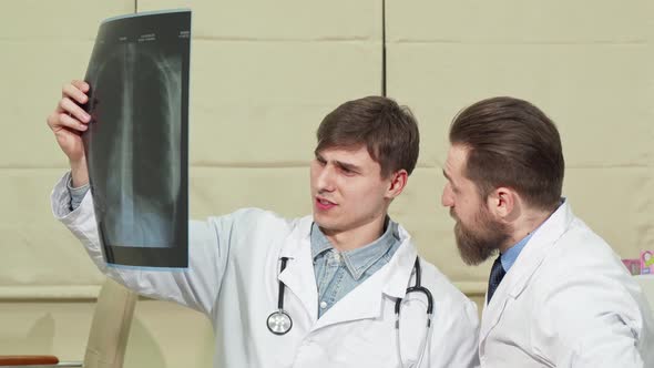 Two Male Doctors Examining Lungs X-ray of a Patient