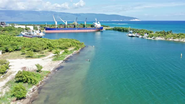 Aerial view of Port of BARAHONA with docking industrial ships during sunny day on Dominican Republic