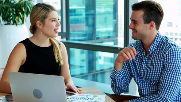 Executives interacting with each other at desk