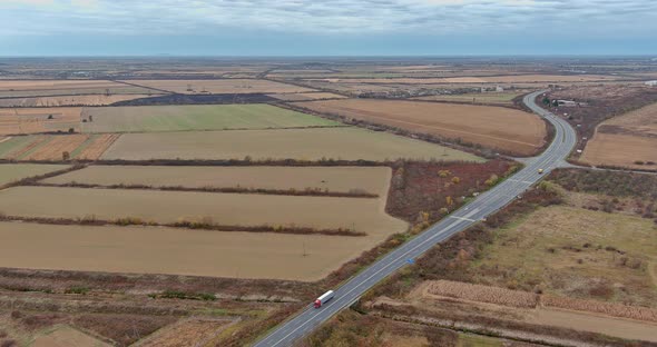 Aerial View Over Road Between Agricultural Fields During a Late Autumn