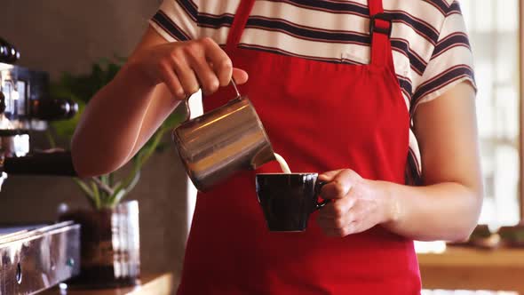 Waitress making cup of coffee at counter in caf������������