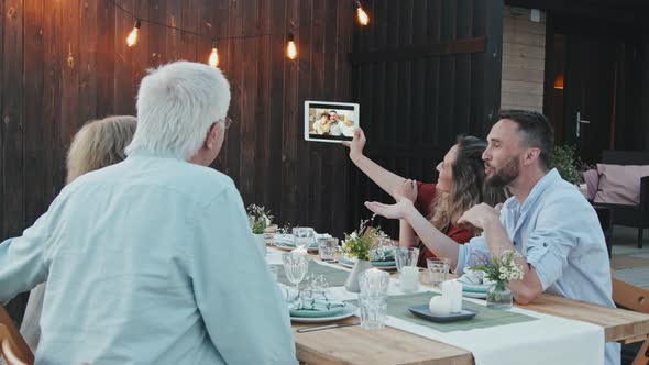 Family Video Calling Outside at Table