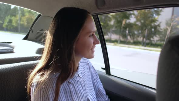 Brunette Girl Rides in Taxi in Backseat Enjoying the Ride