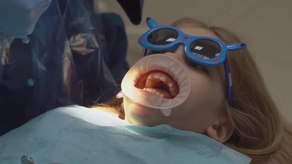 Kid Girl with Oral Dilator at Dentist's Appointment