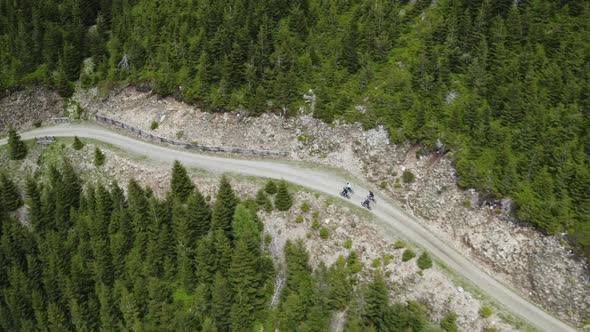 Cyclist group riding bikes on mountain road in Moravia, Czechia, drone.