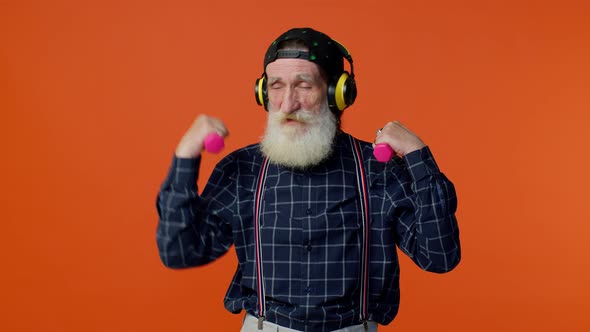 Elderly Bearded Man Listening Music Via Headphones Working Out Lifting Pink Dumbbells Healthcare