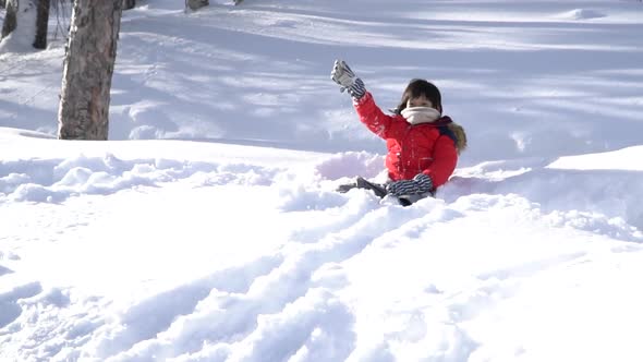 Cute Asian Child Wearing Winter Clothes Playing On Snow In The Park 1