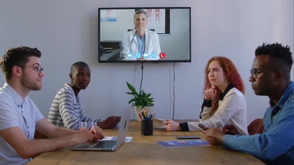 Creative business colleagues in video conference in meeting room in modern office