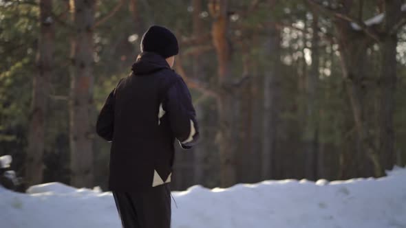 Young Male Athlete Jogging In Wintry Wood