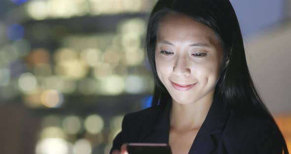 Young businesswoman use of cellphone at night