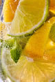 Macro photo of sliced lemon and lime with a leaf of mint and bubbles in glass. Cool drink mojito - PhotoDune Item for Sale