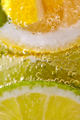 Ripe sliced pieces of lemon and lime in a glass with water and bubbles. Macro photo of summer - PhotoDune Item for Sale
