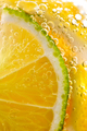 Juicy slices of ripe lemon and lime with bubbles in a glass of water. Macro photo of refreshing - PhotoDune Item for Sale