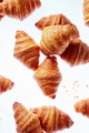 Falling fresh french croissants with crumbs on a light background - PhotoDune Item for Sale