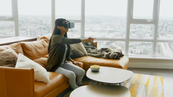 Woman using virtual reality headset in living room